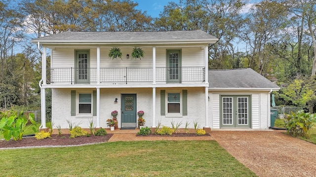 front facade with a balcony and a front lawn