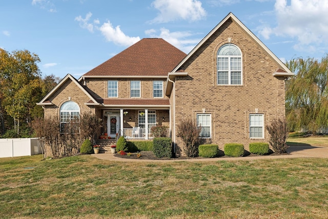 view of front facade with covered porch and a front yard