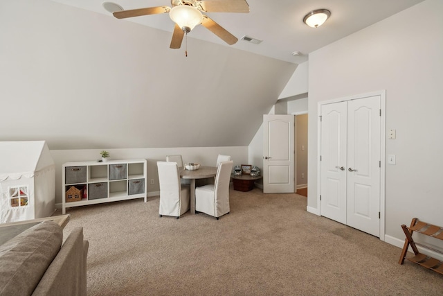 interior space featuring ceiling fan, light carpet, and vaulted ceiling