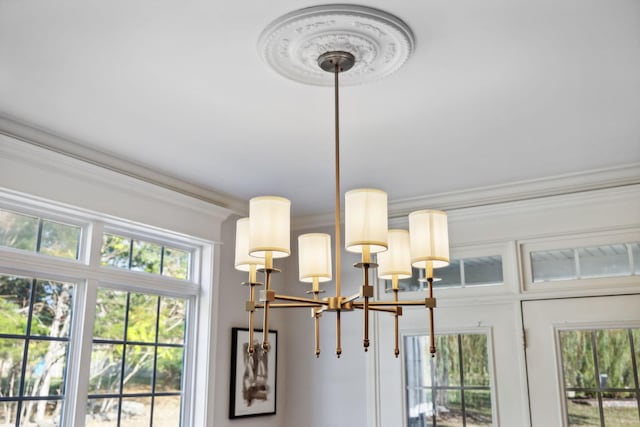 interior details featuring crown molding and an inviting chandelier