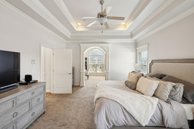 bedroom with ceiling fan, a raised ceiling, light colored carpet, and ornamental molding