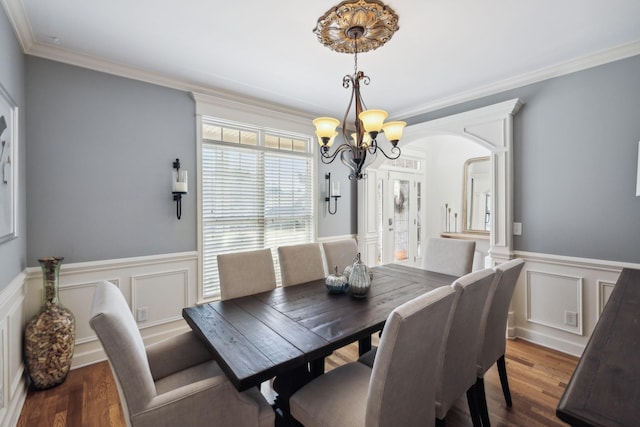 dining room featuring an inviting chandelier, dark wood-type flooring, and ornamental molding