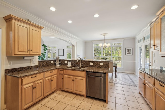 kitchen featuring dishwasher, sink, light tile patterned floors, decorative light fixtures, and kitchen peninsula