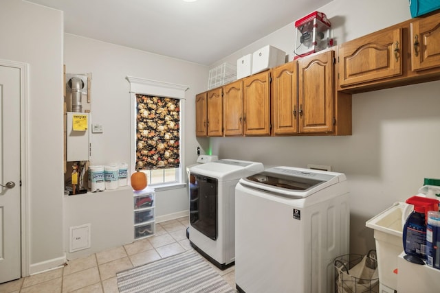 laundry area with cabinets, washer and dryer, and light tile patterned flooring