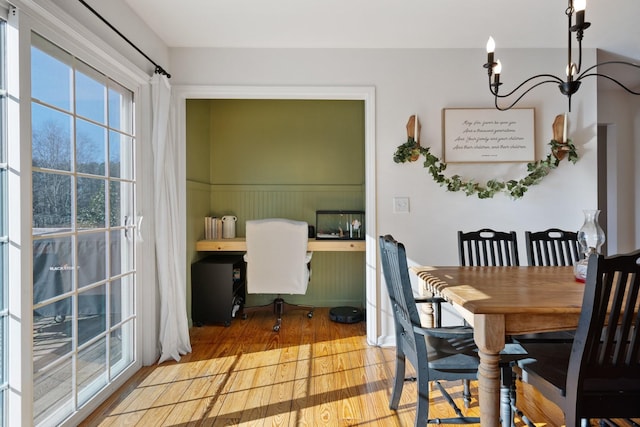 dining space featuring wood-type flooring, an inviting chandelier, and plenty of natural light