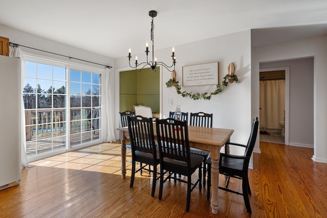 dining area featuring light hardwood / wood-style floors and a chandelier