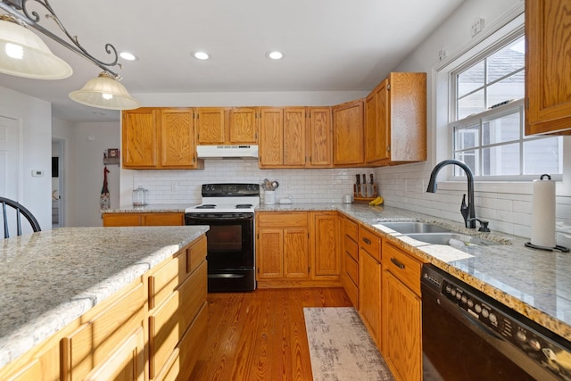 kitchen with range with electric stovetop, decorative light fixtures, light wood-type flooring, black dishwasher, and sink