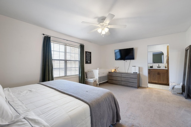 carpeted bedroom with ceiling fan, ensuite bath, and sink