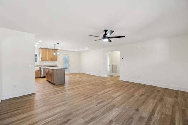 unfurnished living room featuring ceiling fan and light hardwood / wood-style flooring