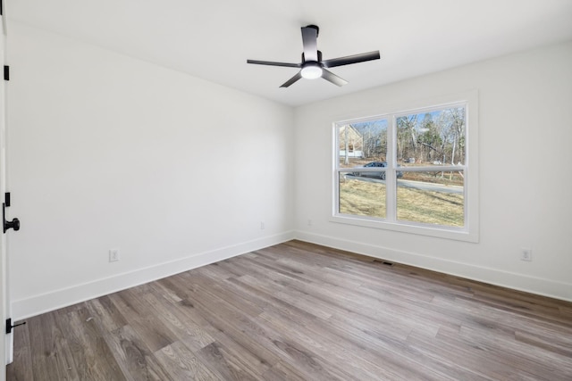 empty room with ceiling fan and light hardwood / wood-style flooring