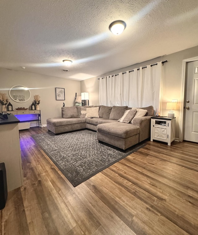 living room with dark wood-type flooring and a textured ceiling