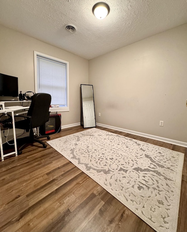 office space with wood-type flooring and a textured ceiling