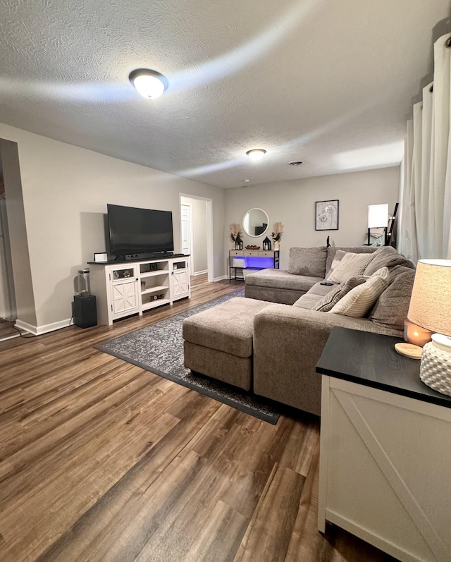 living room featuring dark wood-type flooring and a textured ceiling