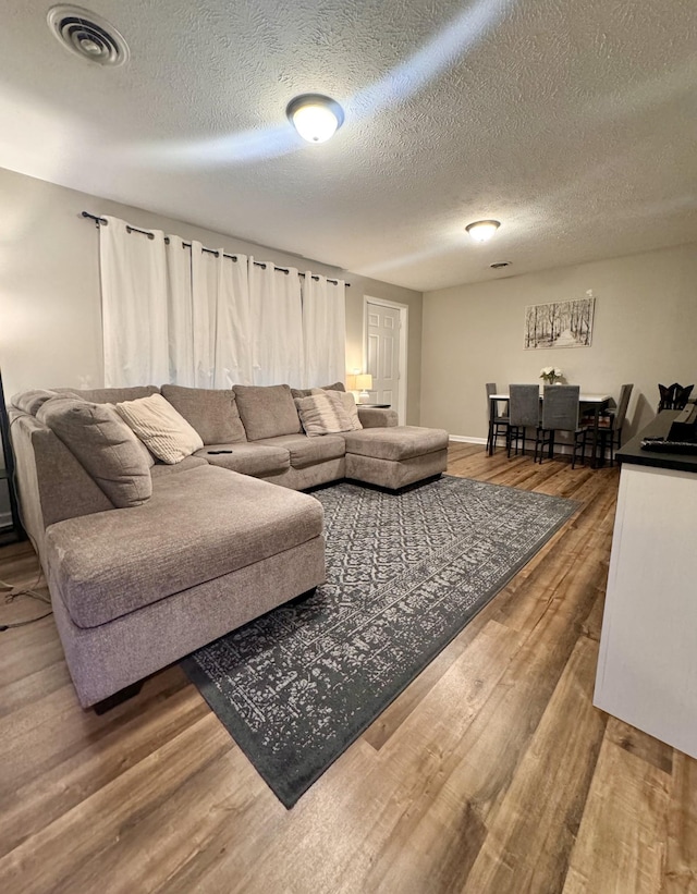 living room with wood-type flooring and a textured ceiling