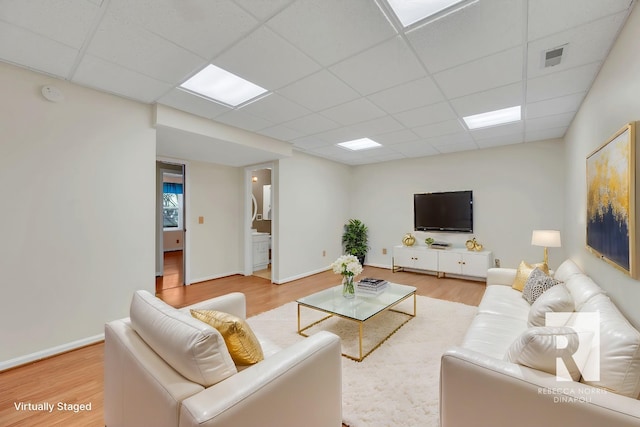 living room featuring wood-type flooring and a paneled ceiling