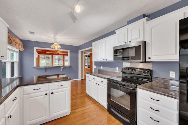 kitchen featuring hanging light fixtures, black appliances, light hardwood / wood-style floors, and white cabinets