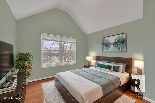 bedroom featuring high vaulted ceiling and light hardwood / wood-style floors