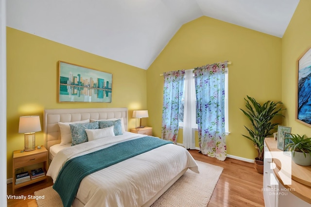 bedroom with light hardwood / wood-style flooring and vaulted ceiling