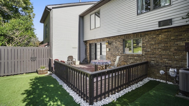 wooden deck featuring a lawn, a patio area, and central AC