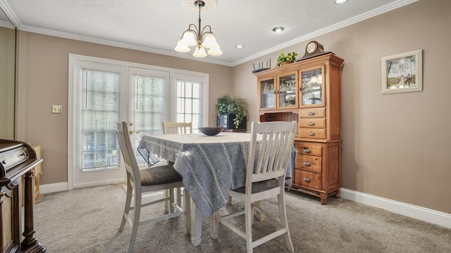 dining area featuring plenty of natural light, crown molding, light carpet, and a chandelier