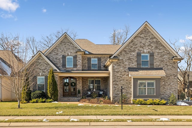 craftsman-style house featuring a porch, french doors, and a front lawn