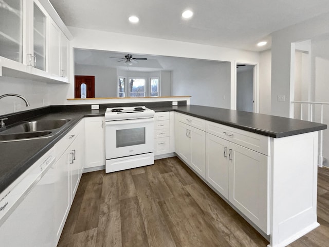 kitchen featuring kitchen peninsula, white cabinetry, and white appliances