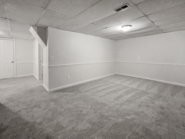 basement featuring a drop ceiling and carpet floors