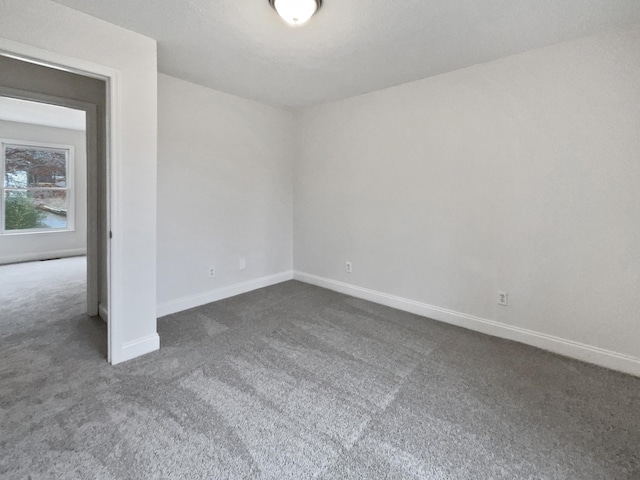 unfurnished room with dark carpet