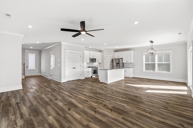 unfurnished living room featuring dark hardwood / wood-style flooring, ceiling fan with notable chandelier, and ornamental molding