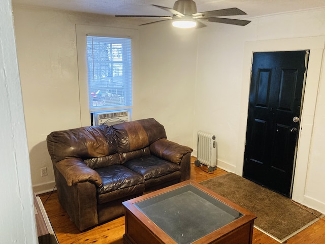 living room featuring hardwood / wood-style flooring, radiator, cooling unit, and ceiling fan