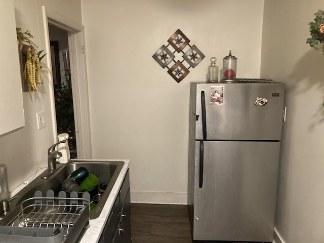 kitchen featuring stainless steel fridge, sink, and dark hardwood / wood-style floors