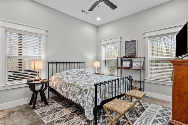 bedroom with multiple windows, concrete floors, and ceiling fan