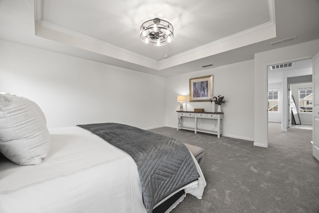 bedroom with crown molding, dark carpet, and a tray ceiling