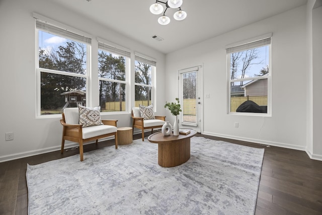 living area with a notable chandelier and dark wood-type flooring