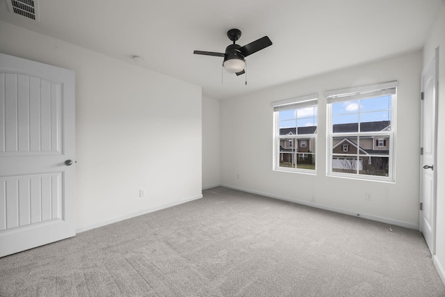 carpeted spare room featuring ceiling fan