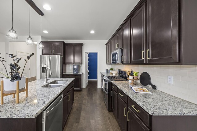 kitchen with sink, a kitchen island with sink, hanging light fixtures, stainless steel appliances, and dark hardwood / wood-style floors