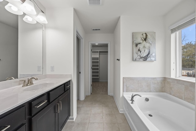 bathroom featuring tile patterned flooring, vanity, and a tub