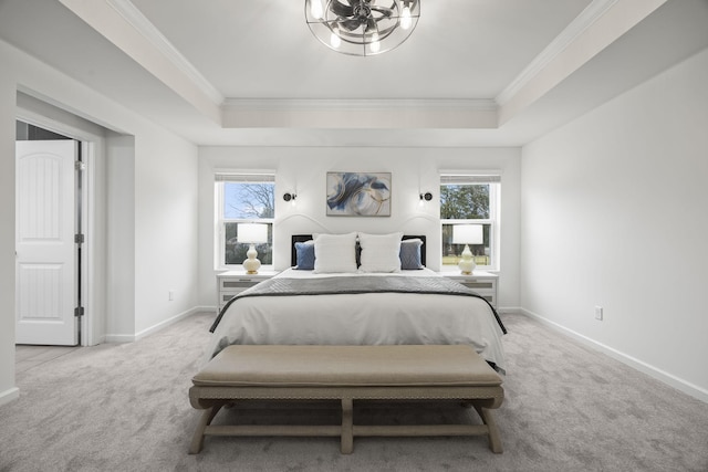 bedroom with a raised ceiling, light carpet, and multiple windows