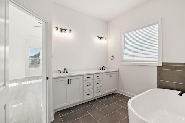 bathroom featuring vanity, a tub to relax in, tile patterned floors, and a wealth of natural light