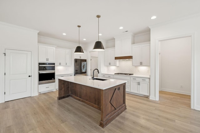 kitchen featuring sink, white cabinets, and a center island with sink