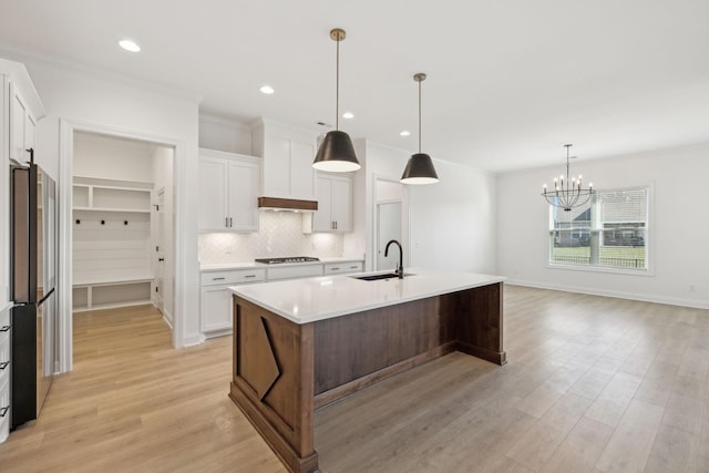 kitchen featuring white cabinetry, a center island with sink, stainless steel appliances, and sink