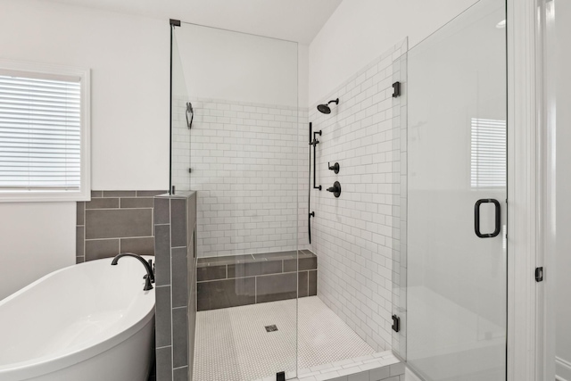 bathroom featuring shower with separate bathtub