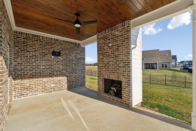 view of patio with ceiling fan and an outdoor brick fireplace