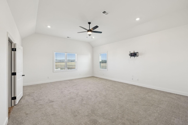 unfurnished room with ceiling fan, light colored carpet, and lofted ceiling