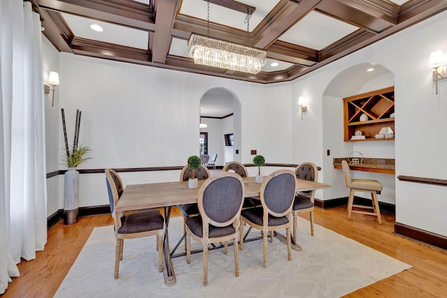 dining space with beamed ceiling, ornamental molding, light hardwood / wood-style flooring, and coffered ceiling