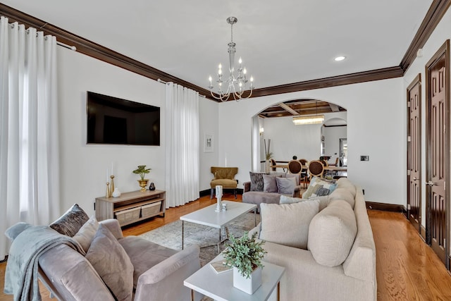 living room with light wood-type flooring, ornamental molding, and a chandelier