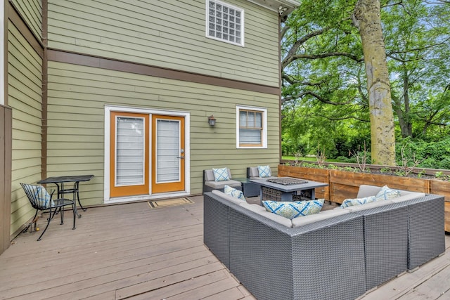 wooden terrace with an outdoor living space with a fire pit