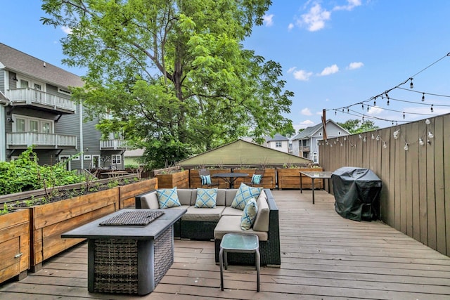 deck featuring grilling area and an outdoor living space with a fire pit