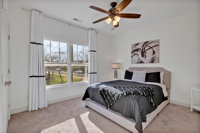 carpeted bedroom featuring ceiling fan and multiple windows