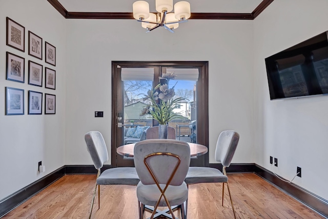 dining area featuring light hardwood / wood-style floors, an inviting chandelier, and ornamental molding